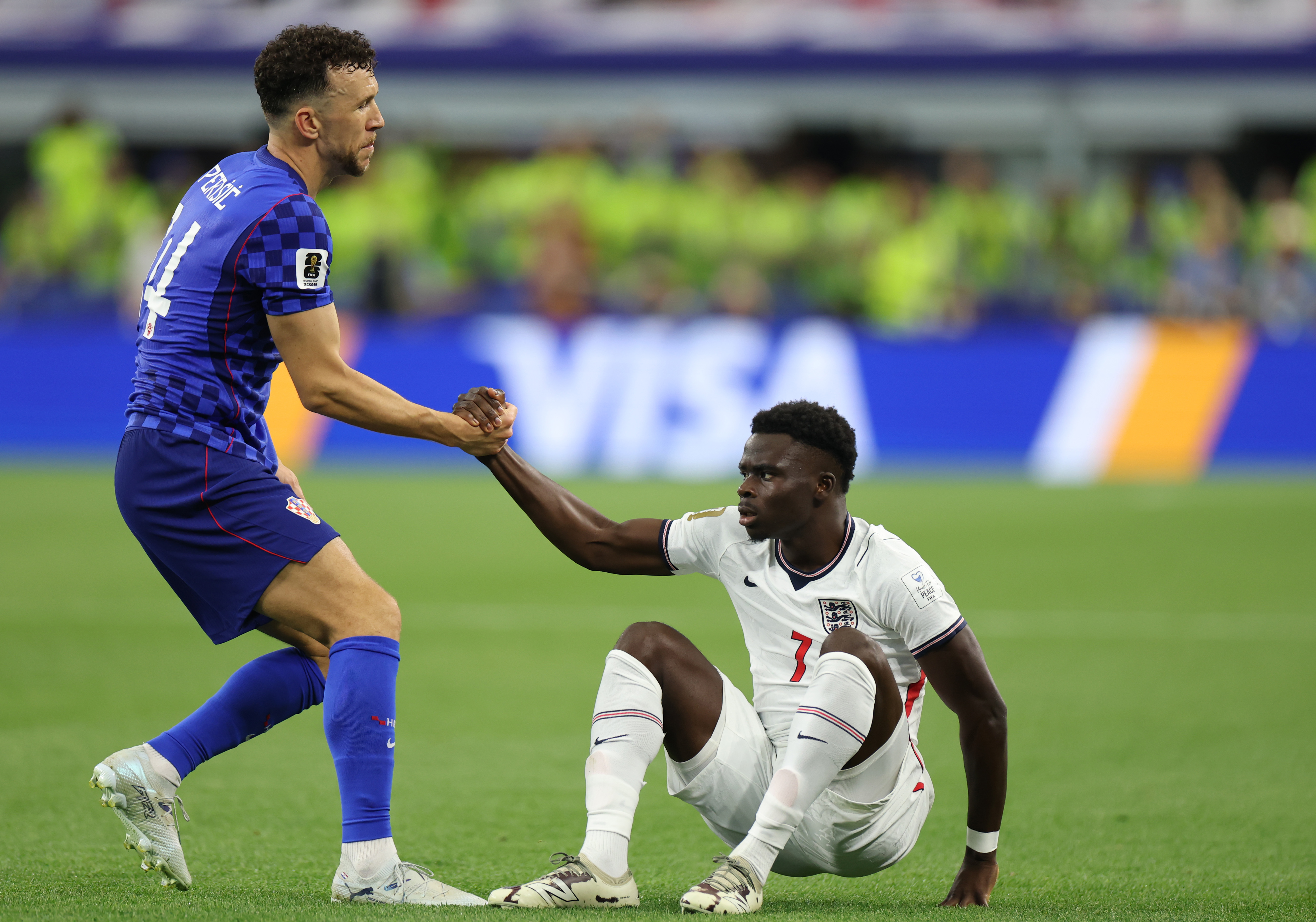 Ivan Perisic #14 of Croatia helps up Bukayo Saka #7 of England during the FIFA World Cup 2026 Group L match between England and Croatia at Dallas Stadium on June 17
