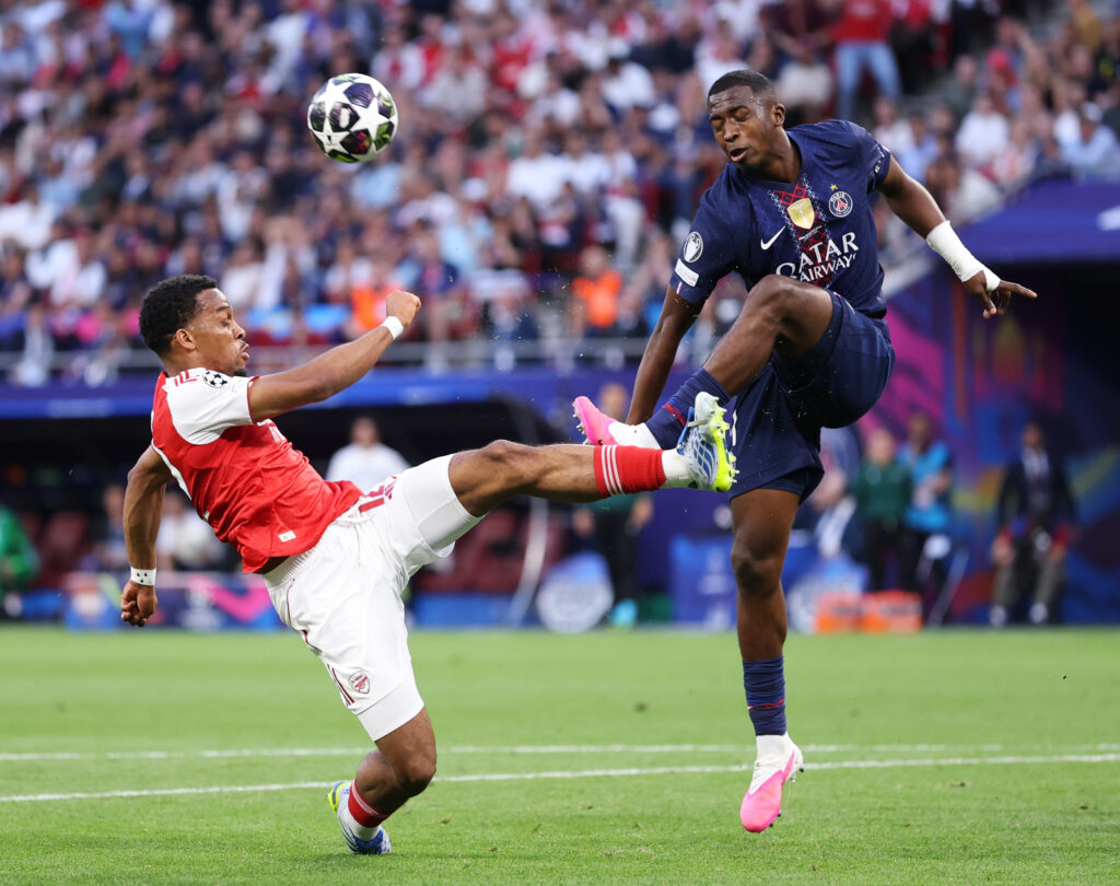 Jurrien Timber of Arsenal challenges William Pacho of Paris Saint-Germain as he clears the ball during the UEFA Champions League Final 2026 match between Paris Saint-Germain
