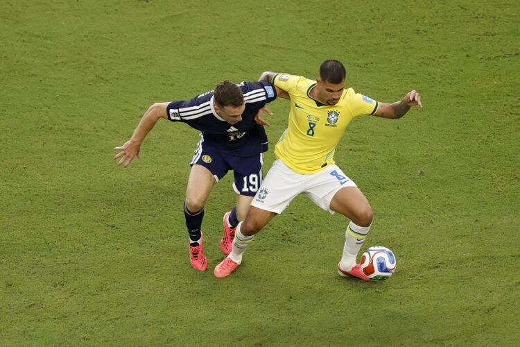 Bruno Guimaraes #8 of Brazil is challenged by Lewis Ferguson #19 of Scotland during the FIFA World Cup 2026 Group C match between Scotland and Braz...
