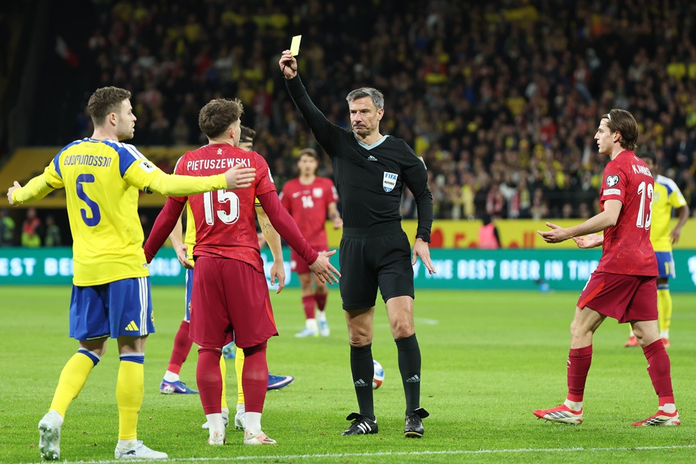 Oskar Pietuszewski of Poland is shown a yellow card by referee Slavko Vincic during the FIFA World Cup 2026 European Qualifiers KO play-offs match between Sweden and Poland at Strawberry Arena on March 31, 2026 in Solna, Sweden. (Photo by Michael Campanella/Getty Images)