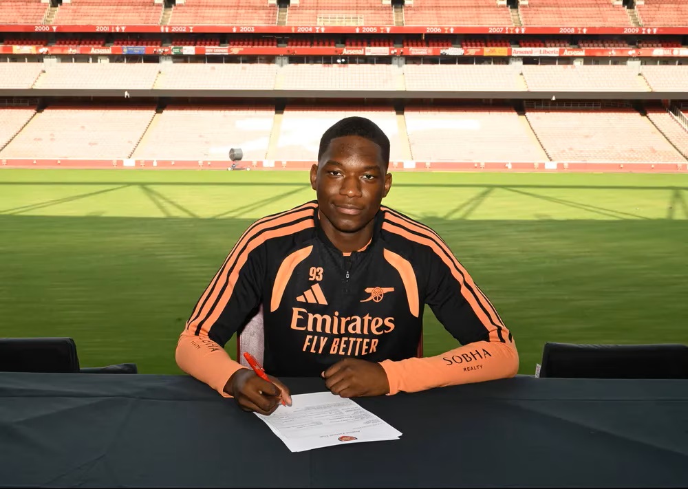 Angelinou Pedro signing scholarship terms with Arsenal (Photo via Arsenal.com)