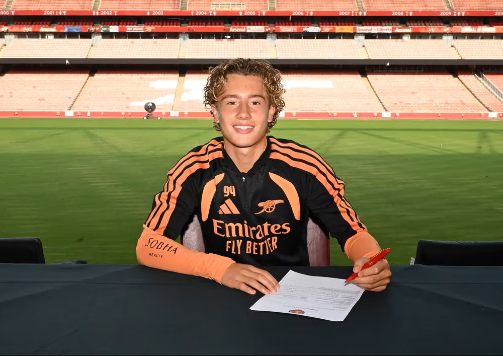 Charlie Purdy signing scholarship terms with Arsenal (Photo via Arsenal.com)