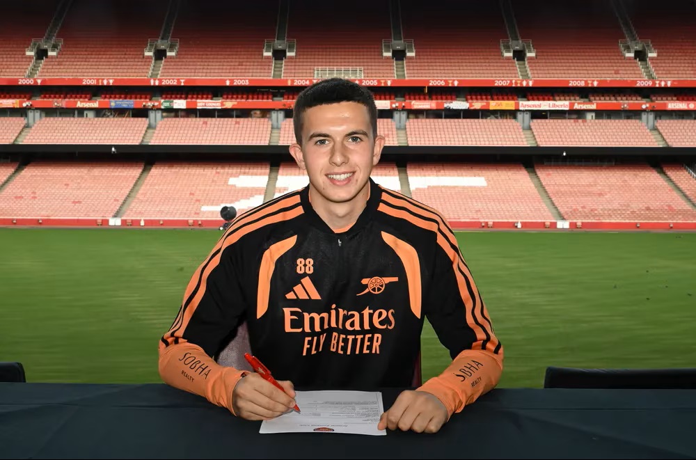 Daniel McCarron signing scholarship terms with Arsenal (Photo via Arsenal.com)