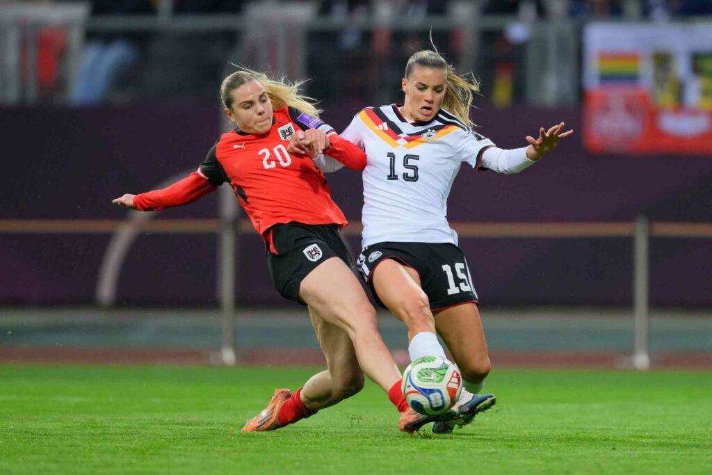 Selina Cerci of Germany tackles Louise Schoeffel of Austria during the 2027 FIFA Women's World Cup Qualifier between Germany and Austria at Max-Morlock-Stadion on April 14, 2026