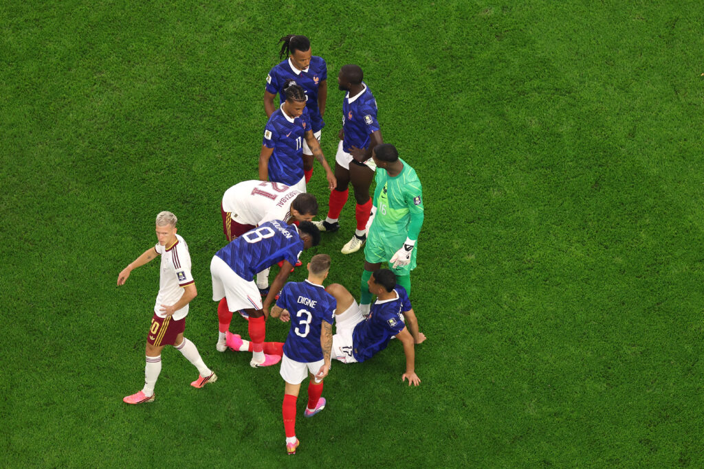 William Saliba #17 of France is attended to by teammates after sustaining an injury during the FIFA World Cup 2026 Semi Final match between France and Spain at Dallas Stadium on July 14