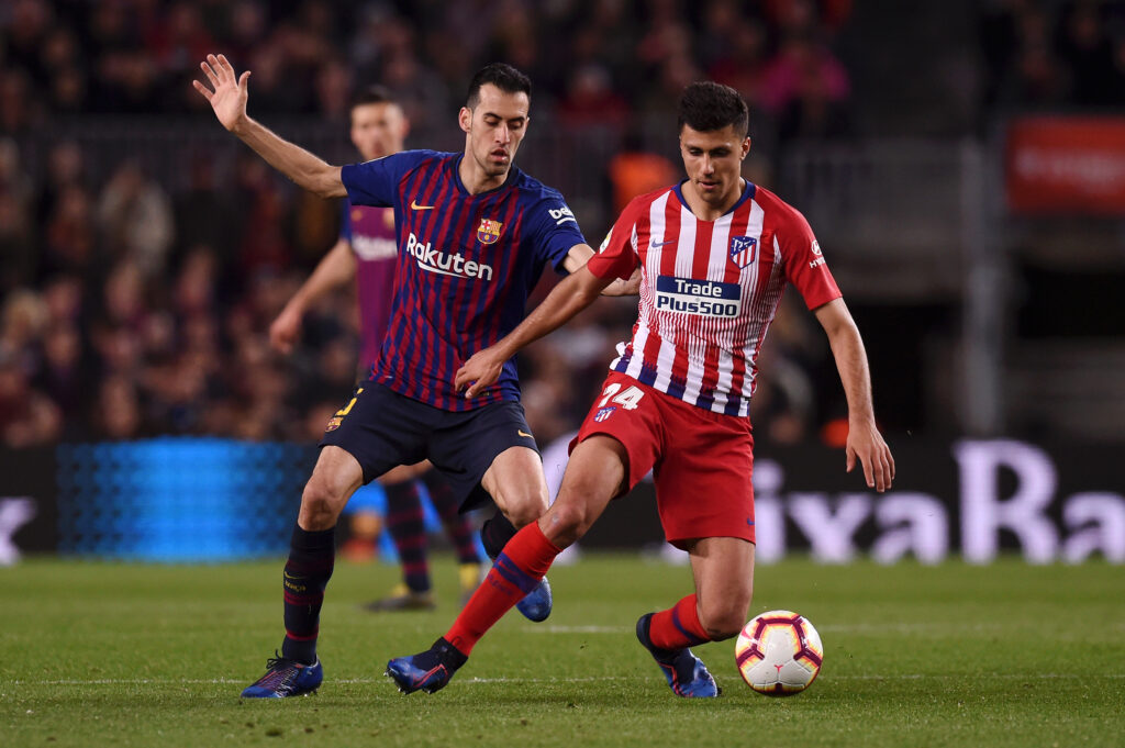 Rodri of Atletico Madrid evades Sergio Busquets of Barcelona during the La Liga match between FC Barcelona and Club Atletico de Madrid at Camp Nou on April 06, 2019
