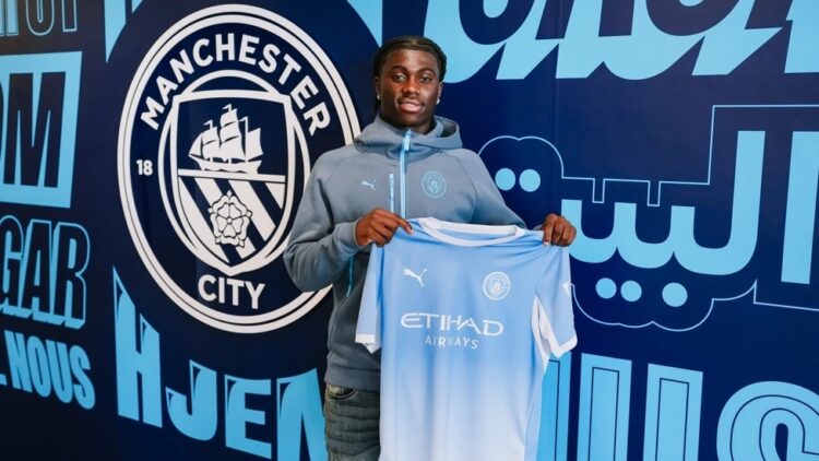 Jeremy Monga signing for Manchester City (Photo via ManCity.com)