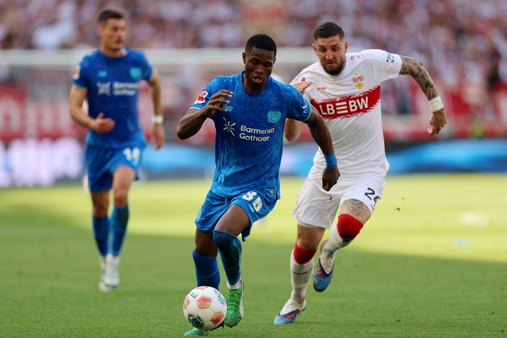Christian Kofane of Bayer 04 Leverkusen runs with the ball while under pressure from Jeff Chabot of VfB Stuttgart during the Bundesliga match between VfB Stuttgart and Bayer 04 Leverkusen at MHPArena on May 09, 2026 in Stuttgart, Germany. (Photo by Adam Pretty/Getty Images)