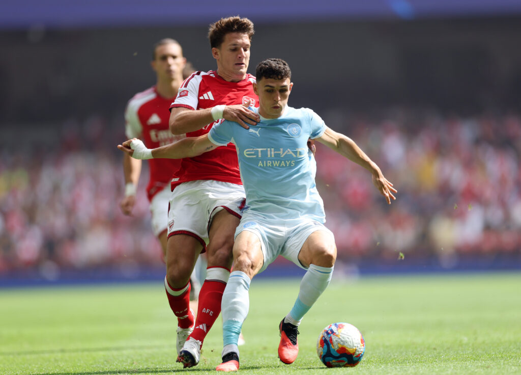 Arsenal boss delivers Odegaard prediction after City win 5 CARDIFF, WALES - AUGUST 16: Phil Foden of Manchester City is challenged by Christos Tzolis of Arsenal during the 2026 FA Community Shield match between Arsenal and Manchester City at Principality Stadium on August 16, 2026 in Cardiff, Wales. (Photo by Carl Recine/Getty Images)