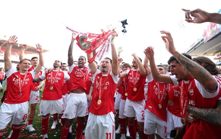 Gabriel Martinelli of Arsenal lifts the Premier League trophy as players of Arsenal celebrate, as they are crowned the Champions of the Premier Lea...