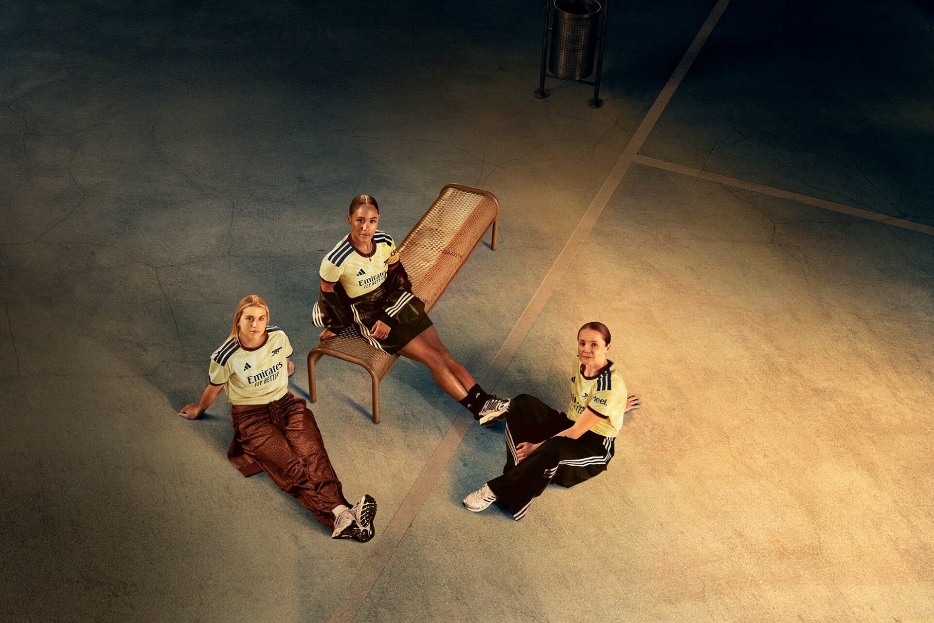 a group of women sitting on a bench in new Arsenal third kit for 26/27