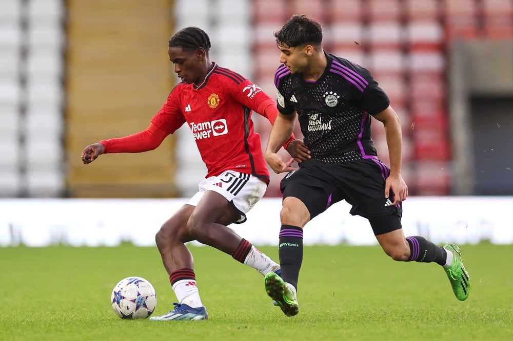 Habeeb Ogunneye of Manchester United is challenged by Emirhan Demircan of Bayern Munich during the UEFA Youth League - Group A match between Manchester United and Bayern Munich at Leigh Sports Village on December 12, 2023 in Leigh, England. (Photo by Lewis Storey/Getty Images)