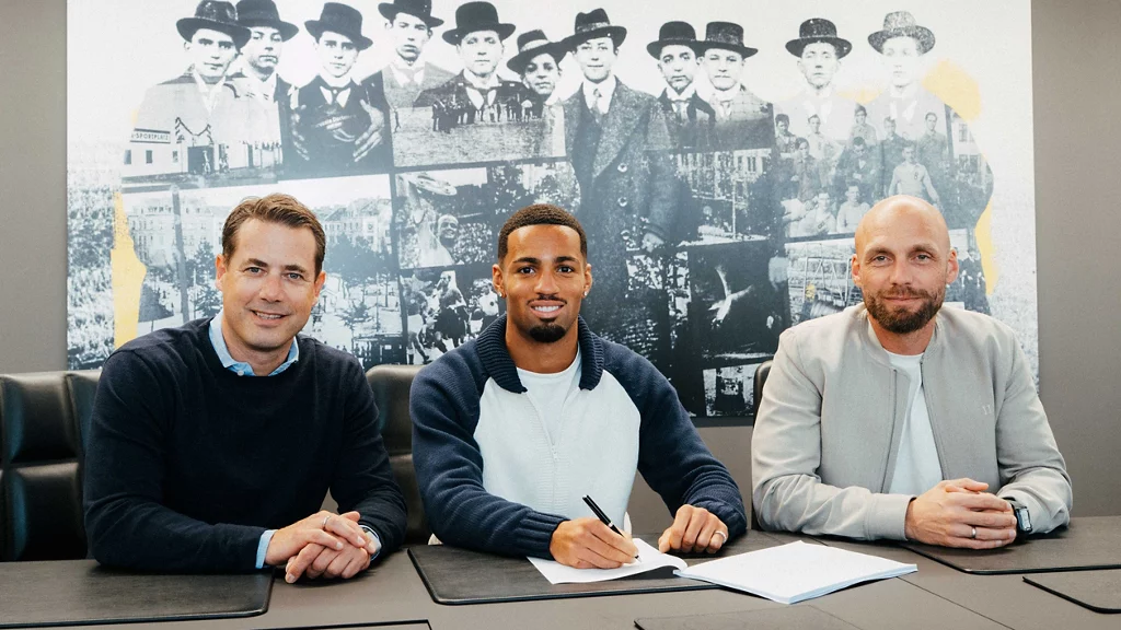 Ethan Nwaneri smiling signs his Borussia Dortmund deal