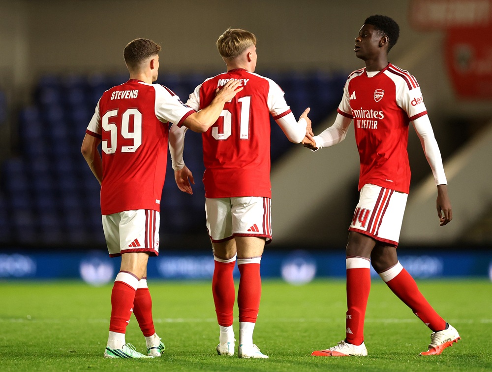 Evan Mooney of Arsenal celebrates scoring his team’s first goal with teammates Archie Stevens and Ife Ibrahim during the Jersey Mike's Trophy match between AFC Wimbledon v Arsenal U21 at The Cherry Red Records Stadium on October 27, 2026 in Wimbledon, England. (Photo by Andrew Redington/Getty Images)