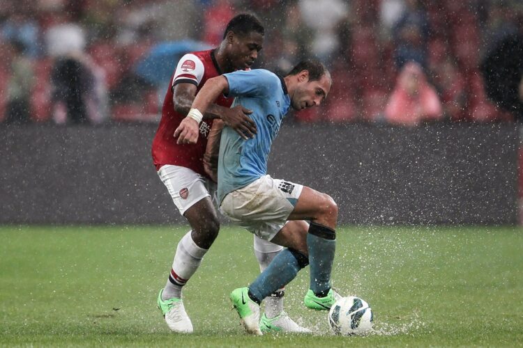 Chuks Aneke (L) of Arsenal FC challenges Pablo Zabaleta of Manchester City during the pre-season Asian Tour friendly match between Arsenal and Manc...