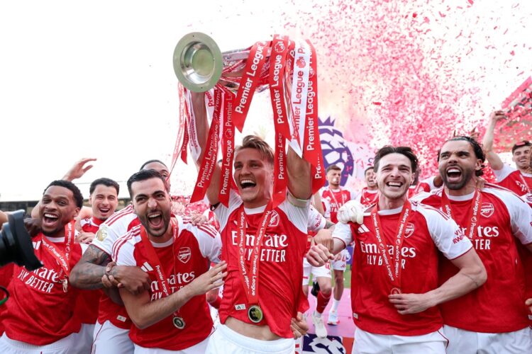 Martin Odegaard of Arsenal lifts the Premier League trophy as players of Arsenal celebrate, as they are crowned the Champions of the Premier League...