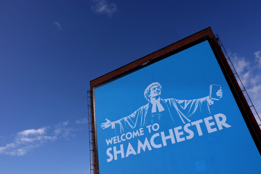 MANCHESTER, ENGLAND - OCTOBER 01: A general view of a billboard displaying the phrase "WELCOME TO SHAMCHESTER" in Manchester on October 01, 2026 in Manchester, England. The Premier League confirmed that City had been found guilty of all charges relating to breaches of its financial regulations between the 2009-10 and 2017-18 seasons. (Photo by Carl Recine/Getty Images)