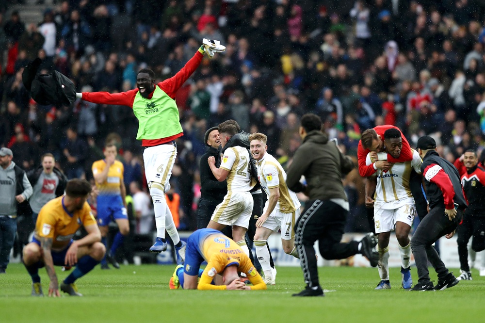 Milton Keynes Dons players celebrate as their team are promoted after the Sky Bet League Two match between Milton Keynes Dons and Mansfield Town at Stadium mk on May 04, 2019 in Milton Keynes, United Kingdom. (Photo by Bryn Lennon/Getty Images)