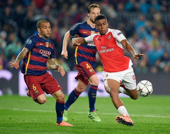 Arsenal's Nigerian forward Alex Iwobi (R) vies with Barcelona's Brazilian defender Dani Alves (L) during the UEFA Champions League Round of 16 second leg football match FC Barcelona vs Arsenal FC at the Camp Nou stadium in Barcelona on March 16, 2016.  / AFP / LLUIS GENE        (Photo credit should read LLUIS GENE/AFP/Getty Images)