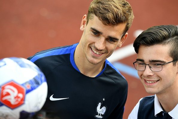 France's forward Antoine Griezmann (L) poses with a fan before a training session at their training ground in Clairefontaine-en-Yvelines, southwest of Paris, on June 6, 2016, ahead of the beginning of the Euro 2016 football tournament. / AFP / FRANCK FIFE (Photo credit should read FRANCK FIFE/AFP/Getty Images)