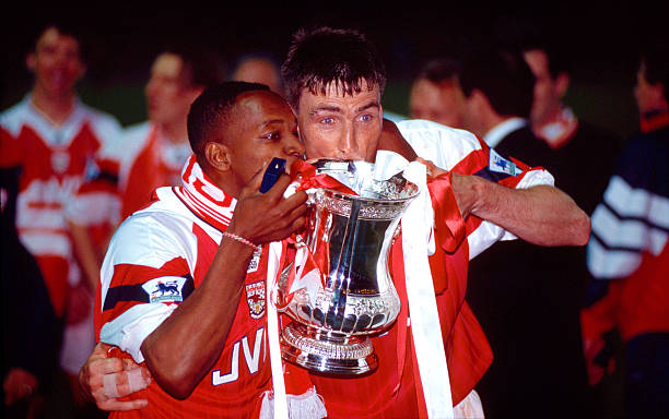 LONDON, UNITED KINGDOM - MAY 20: Arsenal goalscorers Ian Wright (l) and defender Andy Linighan celebrate with the trophy after the 1993 FA Cup Final replay between Arsenal and Sheffield Wednesday at Wembley Stadium on May 20, 1993 in London, England. (Photo by Shaun Botterill/Allsport/Getty Images)