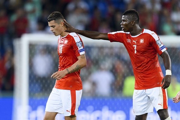 Swiss forward Breel Embolo (R) comforts his teammate Granit Xhaka after he received a red card during the FIFA World Cup WC 2018 football qualifier between Switzerland and Portugal at the St. Jakob-Park stadium in Basel on September 6, 2016. / AFP / FABRICE COFFRINI (Photo credit should read FABRICE COFFRINI/AFP/Getty Images)