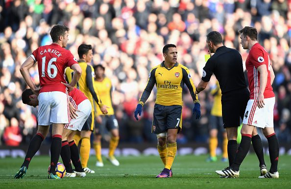 MANCHESTER, ENGLAND - NOVEMBER 19: Alexis Sanchez of Arsenal (C) is shown a yellow card by referee Andre Marriner (CR) during the Premier League match between Manchester United and Arsenal at Old Trafford on November 19, 2016 in Manchester, England. (Photo by Shaun Botterill/Getty Images)