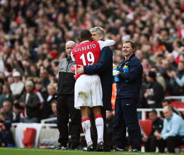 London, UNITED KINGDOM: Arsenal's Captain Gilberto Silva (C) hugs manager Arsene Wenger while team trainer Gary Lewin (R) looks on after he scored his second goal during the Premiership football match at The Emirates Stadium in London 02 December 2006. Arsenal won the game 3-0 with Gilberto getting two goals from the penalty spot. AFP PHOTO ADRIAN DENNIS 