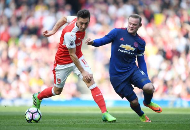 Ozil (L) in action against United on Sunday