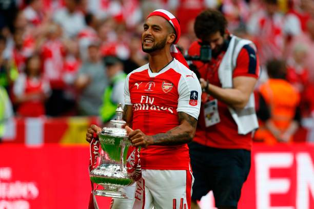 Theo Walcott holds the FA Cup with Arsenal
