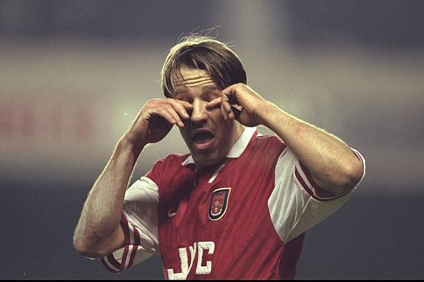 Paul Merson of Arsenal rubs his eyes