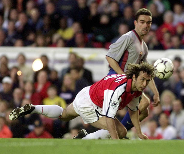 LONDON, UNITED KINGDOM: Barcelona winger Marc Overmars battles with Arsenal defender Gilles Grimandi (L) during tonights testimonial match for Arsenal and England Goalkeeper David Seamen at Highbury, 22 May 2001. Picture: GERRY PENNY/AFP/Getty Images