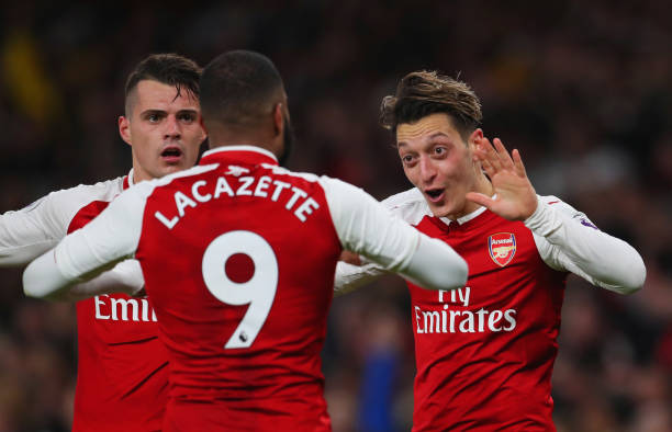 Mesut Ozil of Arsenal (R) celebrates as he scores their third goal with Granit Xhaka and Alexandre Lacazette during the Premier League match between Arsenal and Liverpool at Emirates Stadium on December 22, 2017 in London, England. (Photo by Catherine Ivill/Getty Images)