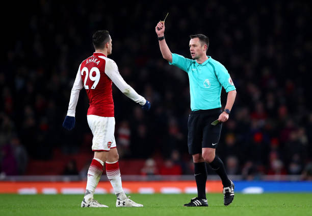 LONDON, ENGLAND - DECEMBER 16: Granit Xhaka of Arsenal is shown a yellow card by referee Stuart Attwell during the Premier League match between Arsenal and Newcastle United at Emirates Stadium on December 16, 2017 in London, England. (Photo by Julian Finney/Getty Images)