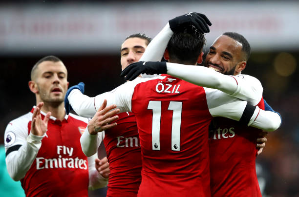 LONDON, ENGLAND - JANUARY 20: Alexandre Lacazette of Arsenal celebrates scoring his side's fourth goal with Mesut Ozil and team mates during the Premier League match between Arsenal and Crystal Palace at Emirates Stadium on January 20, 2018 in London, England. (Photo by Clive Mason/Getty Images)