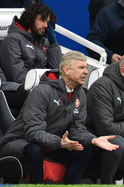 Arsenal's French manager Arsene Wenger reacts in his seat as Arsenal trail, during the English Premier League football match between Brighton and Hove Albion and Arsenal at the American Express Community Stadium in Brighton, southern England on March 4, 2018. Brighton won the game 2-1. (GLYN KIRK/AFP/Getty Images)
