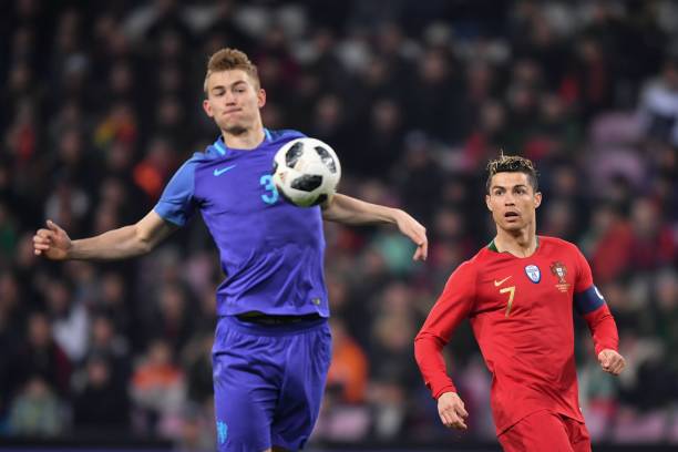 Netherlands' defender Matthijs de Ligt (L) and Portugal's forward Cristiano Ronaldo fight for the ball during their international friendly football match between Portugal and Netherlands at Stade de Geneve stadium in Geneva on March 26, 2018. / AFP PHOTO / Fabrice COFFRINI