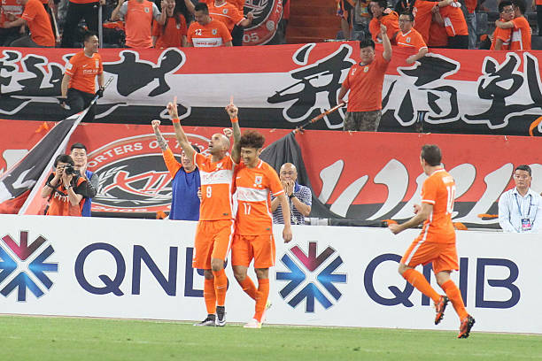 JINAN, CHINA - MAY 18: (CHINA OUT) Diego Tardelli #9 of Shandong Luneng celebrates with team mates after scoring the equalizing goal during the AFC Champions League Round of 16 First Leg match between Shandong Luneng and Sydney FC at Jinan Olympic Sports Centre Stadium on May 18, 2016 in Jinan, China. (Photo by VCG/Getty Images)