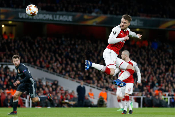 Arsenal's Welsh midfielder Aaron Ramsey scores their third goal with this flick during the UEFA Europa League first leg quarter-final football match between Arsenal and CSKA Moscow at the Emirates Stadium in London on April 5, 2018. / AFP PHOTO / IKIMAGES / Ian KINGTON