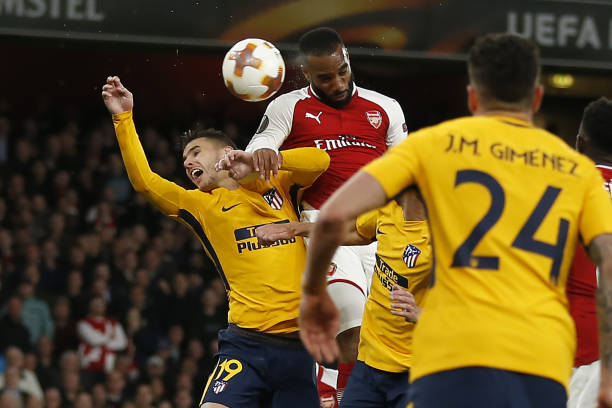 Arsenal's French striker Alexandre Lacazette (C) beats Atletico Madrid's French defender Lucas Hernandez to the headers as he scores the opening goal of the UEFA Europa League first leg semi-final football match between Arsenal and Atletico Madrid at the Emirates Stadium in London on April 26 , 2018. (Photo by Ian KINGTON / IKIMAGES / AFP)