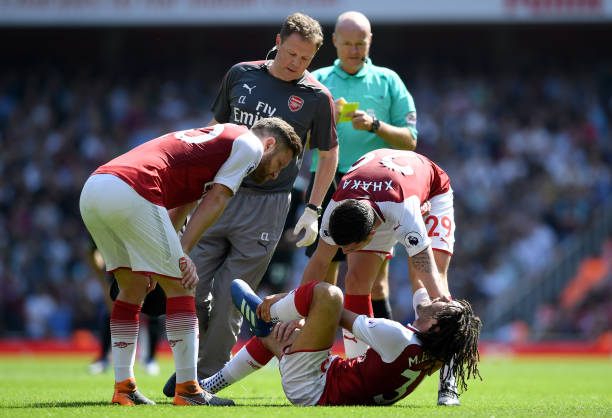 LONDON, ENGLAND - APRIL 22: Granit Xhaka checks if Mohamed Elneny of Arsenal is ok as the medical team arrive on pitch during the Premier League match between Arsenal and West Ham United at Emirates Stadium on April 22, 2018 in London, England. (Photo by Shaun Botterill/Getty Images)