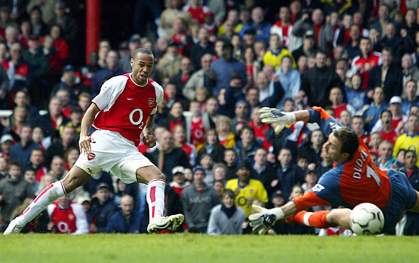 LONDON, UNITED KINGDOM: Arsenal's French forward Thierry Henry (L) puts the ball beyond Liverpool goalie Jerzy Dudek for his second goal of the day during their premier league clash at Highbury in London, 09 April 2004. AFP PHOTO / ODD ANDERSEN