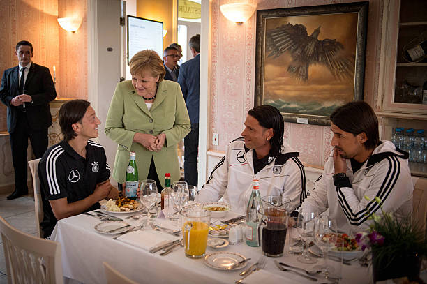 SOPOT, POLAND - JUNE 06: In this photo provided by the German Government Press Office (BPA), German Chancellor Angela Merkel talks to German National Team players Mesut Oezil (L), Tim Wiese (C) and Sami Khedira during a shared dinner at the Euro 2012 Team Hotel on June 6, 2012 in Sopot, Poland. (Photo by Guido Bergmann/Bundesregierung-Pool via Getty Images)