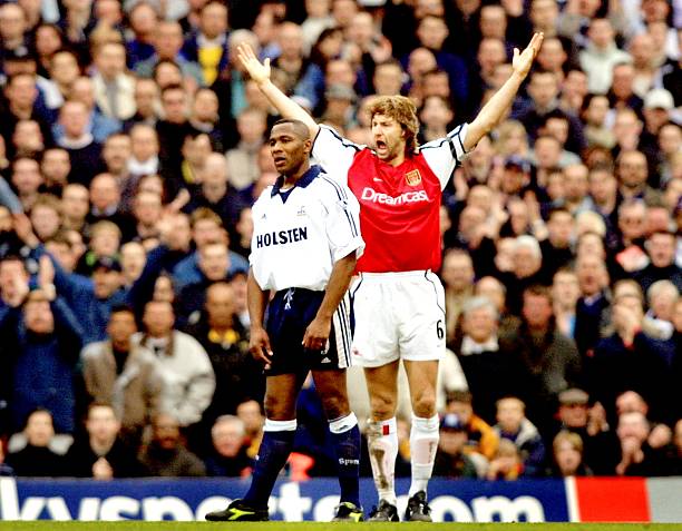 ONDON, UNITED KINGDOM: Arsenal's veteran Tony Adams (R) marshals his defence while he marks Tottenham's Les Ferdinand (L) during the premiership match at Highbury in London 31 March 2001. Arsenal won the game over north London rivals after Frenchmen Thierry Henry and Robert Pires scored a goal each to give Arsenal a 2-0 victory. AFP PHOTO: Adrian DENNIS