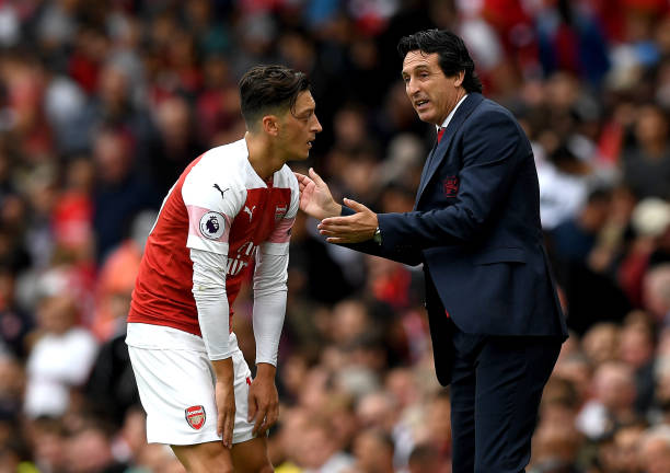 LONDON, ENGLAND - AUGUST 12: Unai Emery, Manager of Arsenal speaks with Mesut Ozil of Arsenal during the Premier League match between Arsenal FC and Manchester City at Emirates Stadium on August 12, 2018 in London, United Kingdom. (Photo by Shaun Botterill/Getty Images)