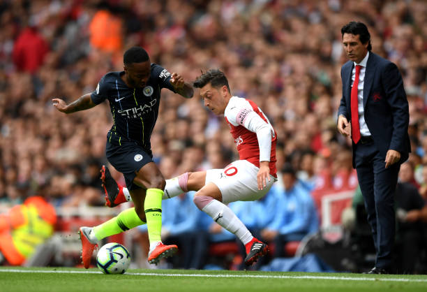 LONDON, ENGLAND - AUGUST 12: Raheem Sterling of Manchester City and Mesut Ozil of Arsenal battle for the ball during the Premier League match between Arsenal FC and Manchester City at Emirates Stadium on August 12, 2018 in London, United Kingdom. (Photo by Shaun Botterill/Getty Images)