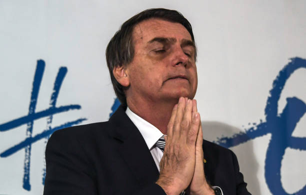 Brazilian deputy Jair Bolsonaro gestures during a press conference he called to announce his intention to run for the Brazilian presidency in the October 2018 presidential election, at a hotel in Rio de Janeiro on August 10, 2017. A controversial politician and former army paratrooper, Bolsonaro called himself the 'patriot' Brazil needs, adding he is the answer to Brazil's rampant corruption, crime and economic malaise. He won more votes than any other congressman from Rio de Janeiro state in the last general elections in 2014 and polls currently show him tied in second place for the presidency, behind leftist former two term president Luiz Inacio Lula da Silva. / AFP PHOTO / Apu Gomes