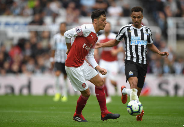 NEWCASTLE UPON TYNE, ENGLAND - SEPTEMBER 15: Newcastle player Jacob Murphy (r) looks on as Mesut Ozil of Arsenal makes a pass during the Premier League match between Newcastle United and Arsenal FC at St. James Park on September 15, 2018 in Newcastle upon Tyne, United Kingdom. (Photo by Stu Forster/Getty Images)