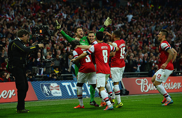 LONDON, ENGLAND - APRIL 12: Lukasz Fabianski of Arsenal celebrates winning the penalty shoot out with team mates during the FA Cup Semi-Final match between Wigan Athletic and Arsenal at Wembley Stadium on April 12, 2014 in London, England.  (Photo by Shaun Botterill/Getty Images)