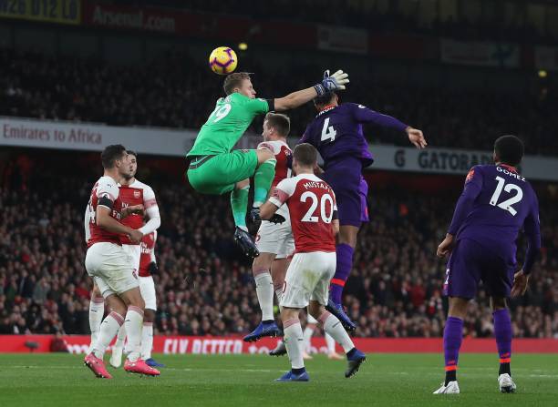 Arsenal's German goalkeeper Bernd Leno (C) jumps but misses the ball as Liverpool's Dutch defender Virgil van Dijk (2R) has an attempt on goal during the English Premier League football match between Arsenal and Liverpool at the Emirates Stadium in London on November 3, 2018. (Photo by Daniel LEAL-OLIVAS / AFP) / RESTRICTED TO EDITORIAL USE. No use with unauthorized audio, video, data, fixture lists, club/league logos or 'live' services. Online in-match use limited to 120 images. An additional 40 images may be used in extra time. No video emulation. Social media in-match use limited to 120 images. An additional 40 images may be used in extra time. No use in betting publications, games or single club/league/player publications. /         (Photo credit should read DANIEL LEAL-OLIVAS/AFP/Getty Images)